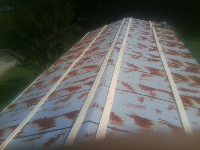 Rusted metal roof panels with new wood purlins before replacement — Storm Damage Roof Repair in Peconic by Roofing Brothers